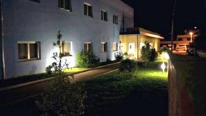 Un edificio de varios pisos con ventanas iluminadas y una entrada bien iluminada.