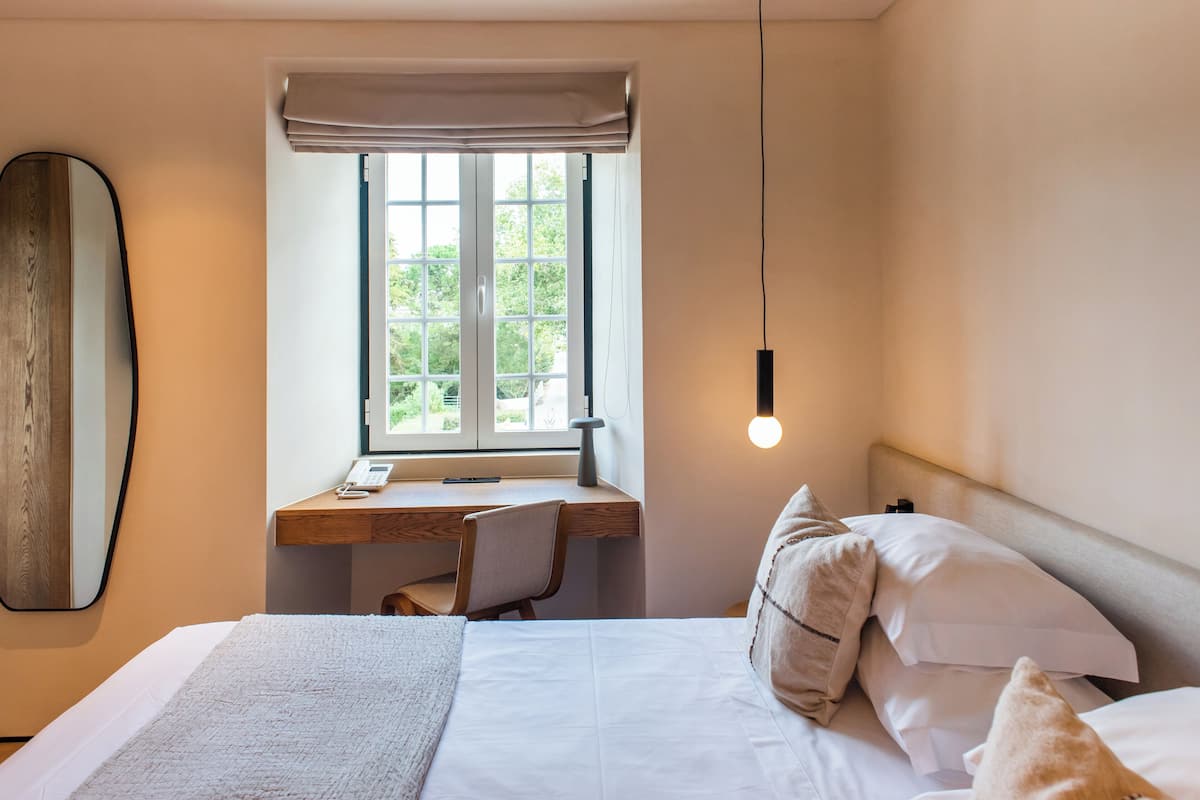 Ein Schlafzimmer mit Bett, Schreibtisch und Fenster.