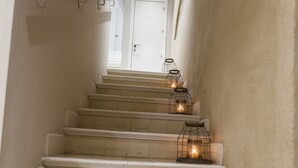 A staircase with white steps and a handrail, decorated with three candle-like lights in wire cages. - Hotel Boutique Elvira Plaza (Seville)