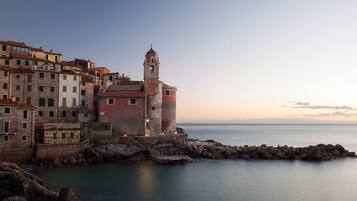 Una cittadina costiera con edifici storici e un faro ben visibile.