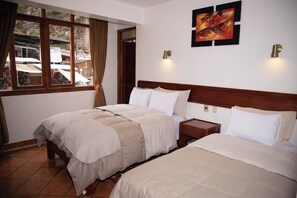 A hotel room with two beds, a window with curtains, a wall-mounted light, and a painting.