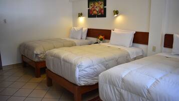 Ein Hotelzimmer mit drei Einzelbetten, jedes mit einem Holzschrankgabez und weißer Bettwäsche. Darüber an der Wand hängt ein Gemälde, und auf beiden Seiten befinden sich Wandleuchten.