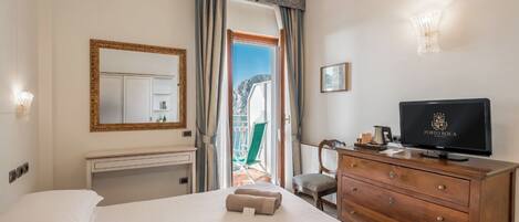 Una habitación de hotel con una cama, un aparador de madera, un televisor y vistas al exterior.