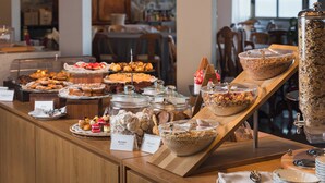 A buffet with various desserts and snacks, including meringues, biscotti, and a large container of granola. - Hotel Porto Roca (Monterosso al Mare)