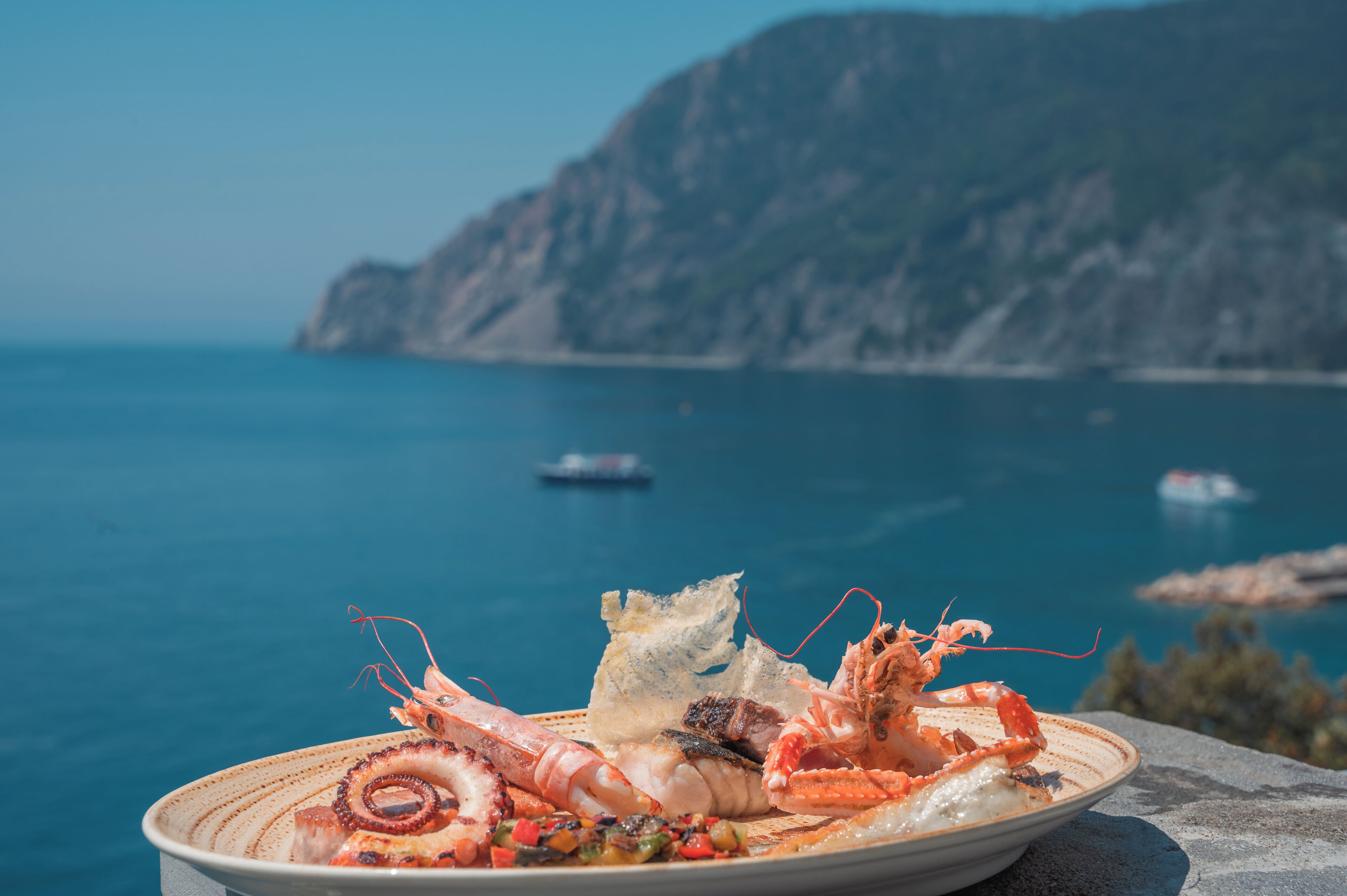 A seafood dish on a plate with a coastal view in the background.