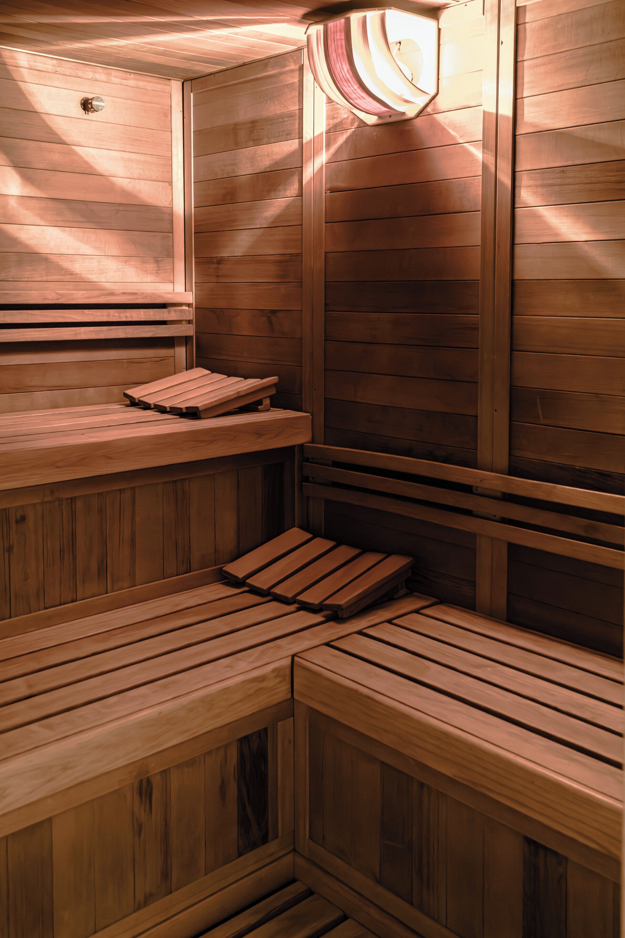 A sauna with wooden benches and a sloped ceiling.