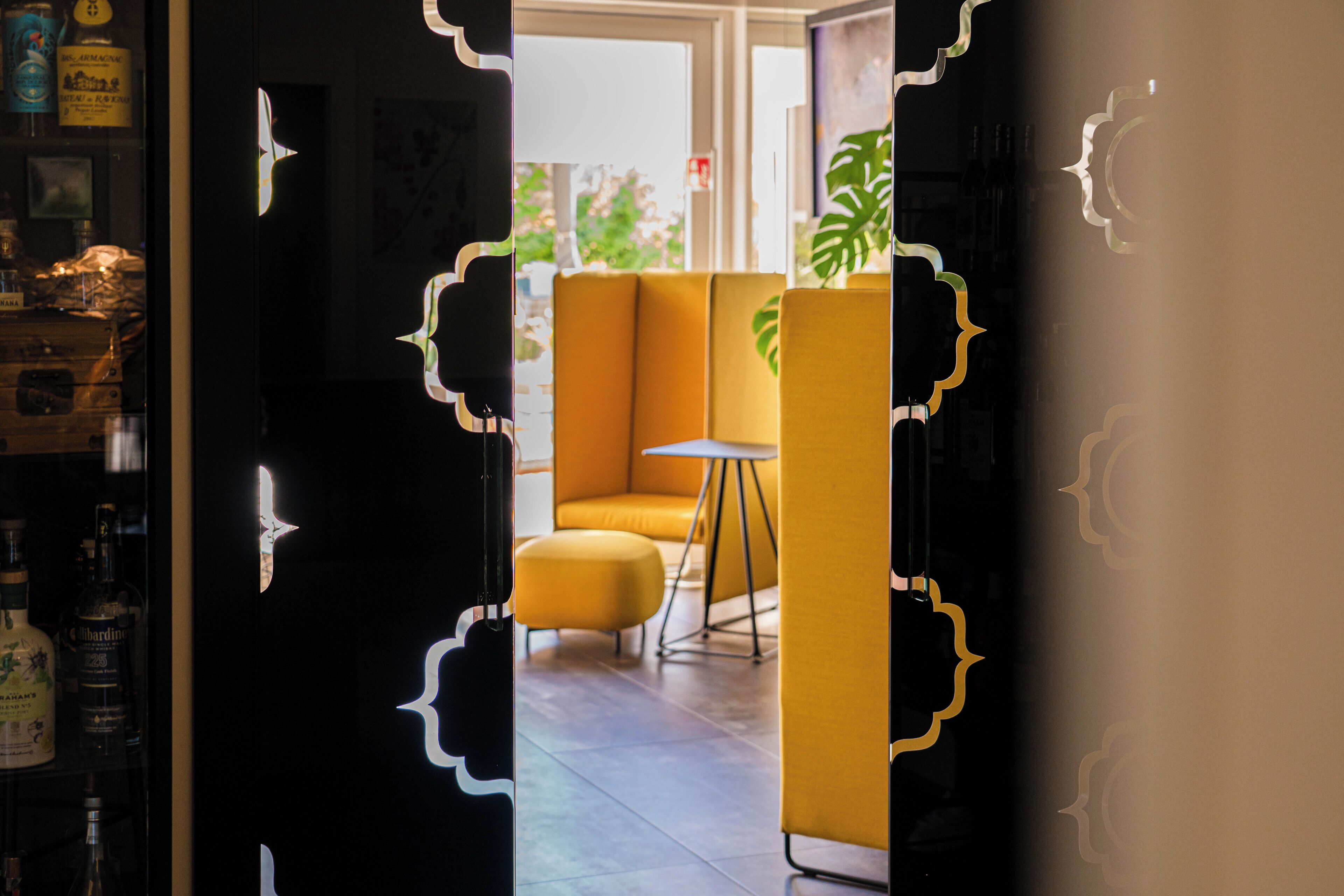 A modern interior with a yellow seating area, a small table, and a view through a doorway.