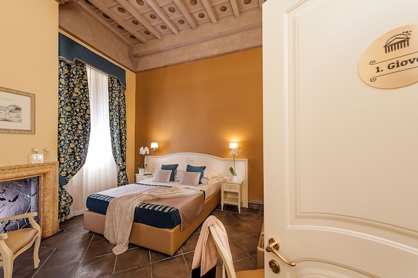 Une chambre d’hôtel avec un lit, des tables de chevet, une lampe, une cheminée et une porte avec une pancarte.
