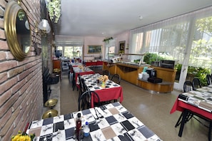 Formal dining area with brick walls, large windows, and elegant table settings.