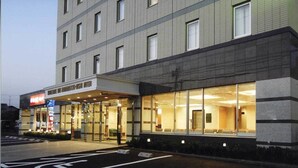 Een hotel met een moderne gevel, grote glazen ramen en een duidelijke ingang.