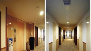 Een hotelgang met vloerbedekking, een receptiebalie en een automaat.