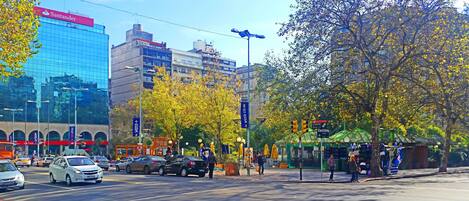 A busy urban street with cars, pedestrians, and various buildings including a Santander bank.