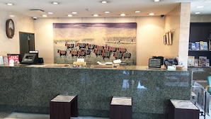 A hotel reception area with a large wall mural of horses, a reception desk, and a key drop station. - Ace Inn Matsuzaka (Matsusaka)