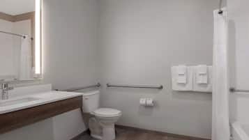 Un baño moderno con inodoro, lavamanos y ducha.