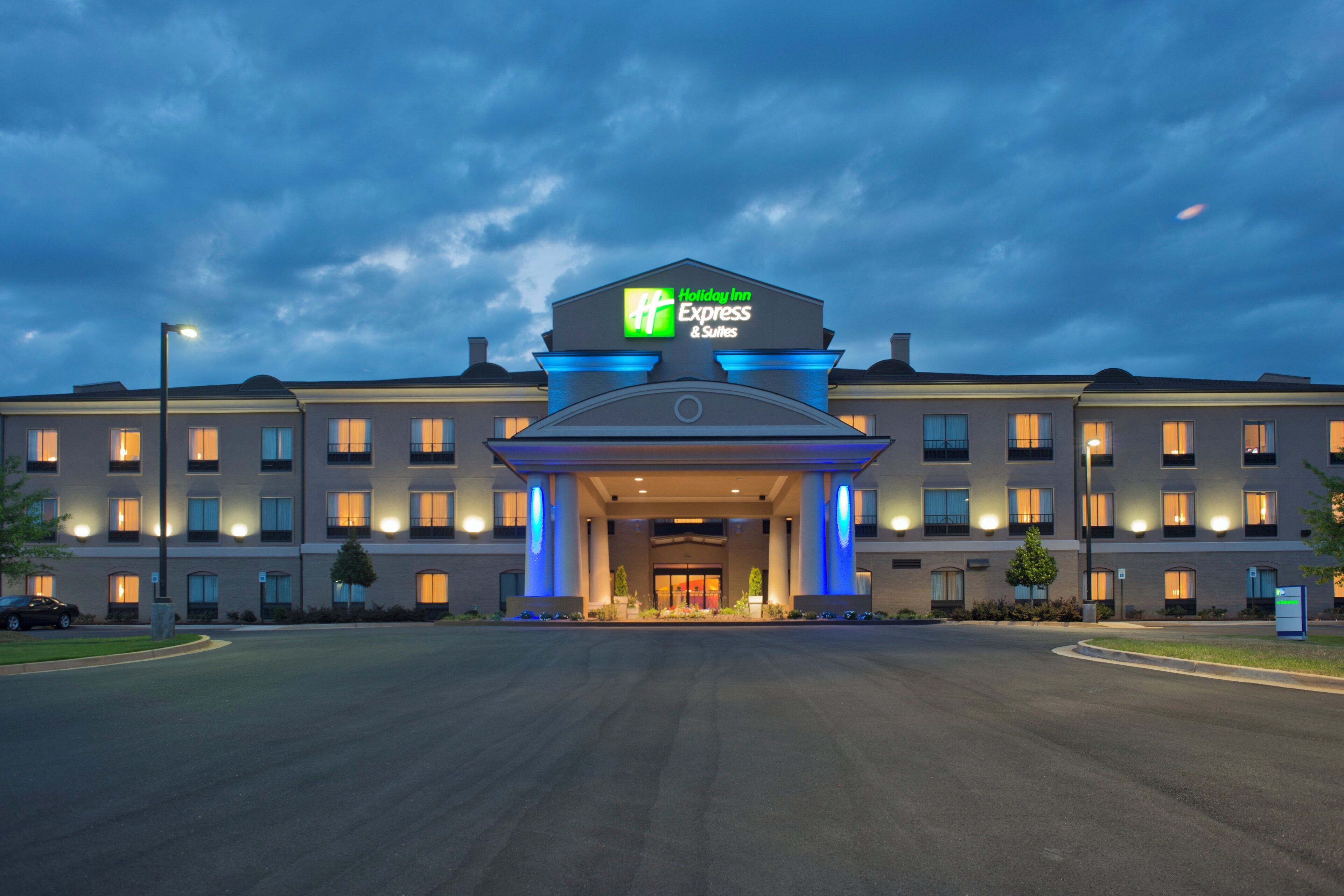 Edificio de Holiday Inn Express & Suites con entrada destacada y señalización iluminada.