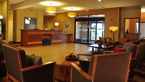 A lobby with a reception desk, seating area, and large windows. - Holiday Inn Express Hotel & Suites Prattville South by IHG (Prattville)