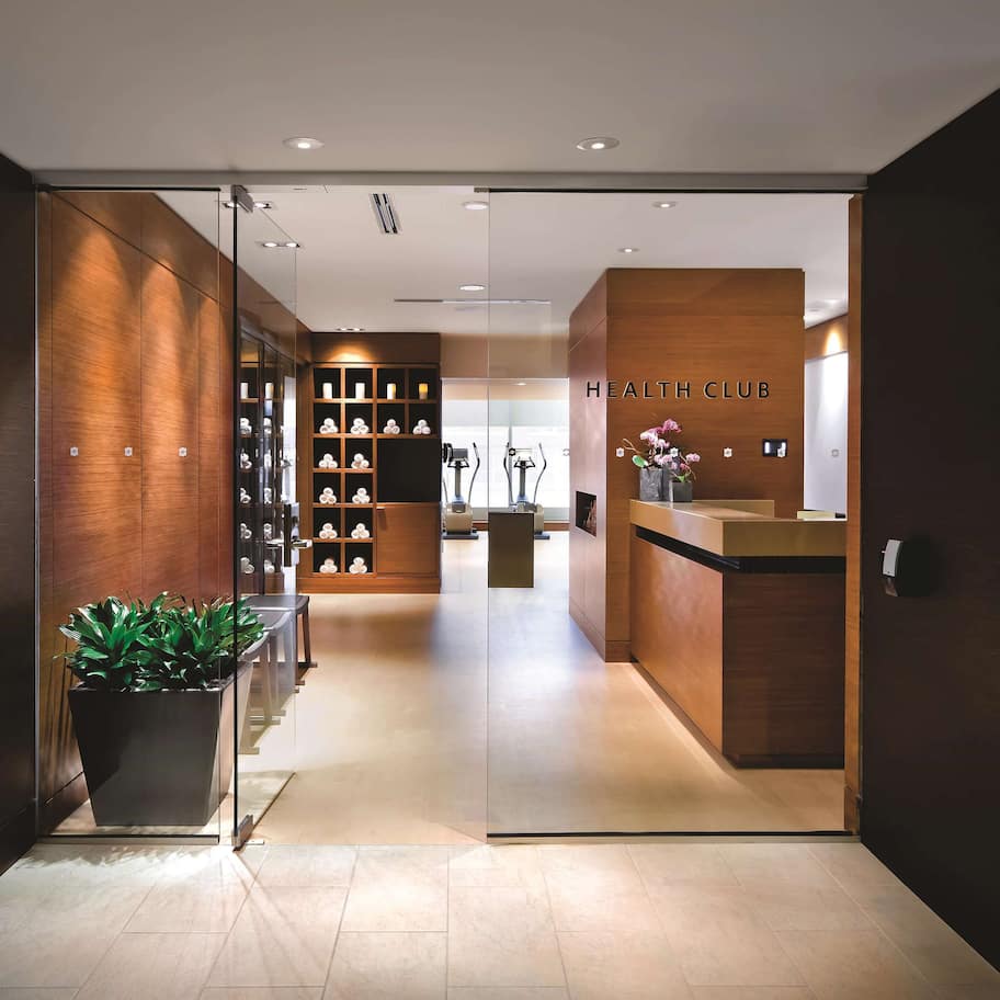 A modern health club interior with a reception desk, exercise equipment, and a well-organized reception area.