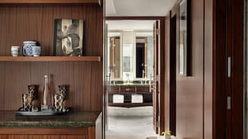 Un baño moderno con tocador de mármol, un espejo grande y un mueble de tocador de madera con adornos.
