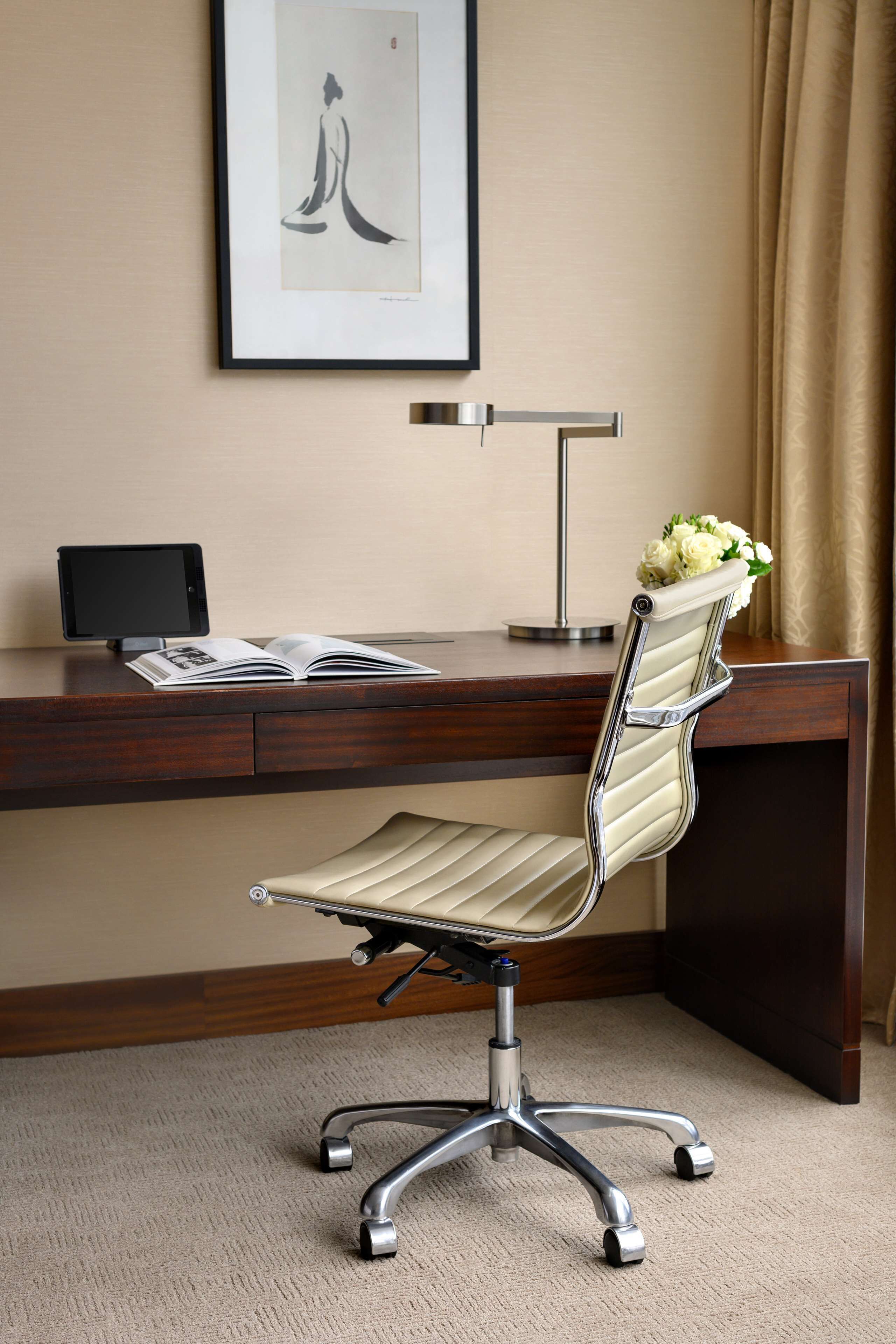 Un fauteuil de bureau moderne doté d’un siège et d’un dossier rembourrés, d’une structure en métal et d’un repose-pieds.
