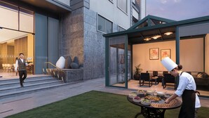 A chef grilling outdoors with a dining area and a building entrance in the background. - The Aarlis Hotel Panchkula, Vignette Collection by IHG (Panchkula)