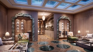A luxurious hotel lobby with a grand staircase, marble flooring, and elegant furniture.