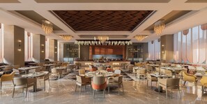A spacious dining area with multiple tables and chairs, a central bar, and a modern ceiling design. - The Aarlis Hotel Panchkula, Vignette Collection by IHG (Panchkula)