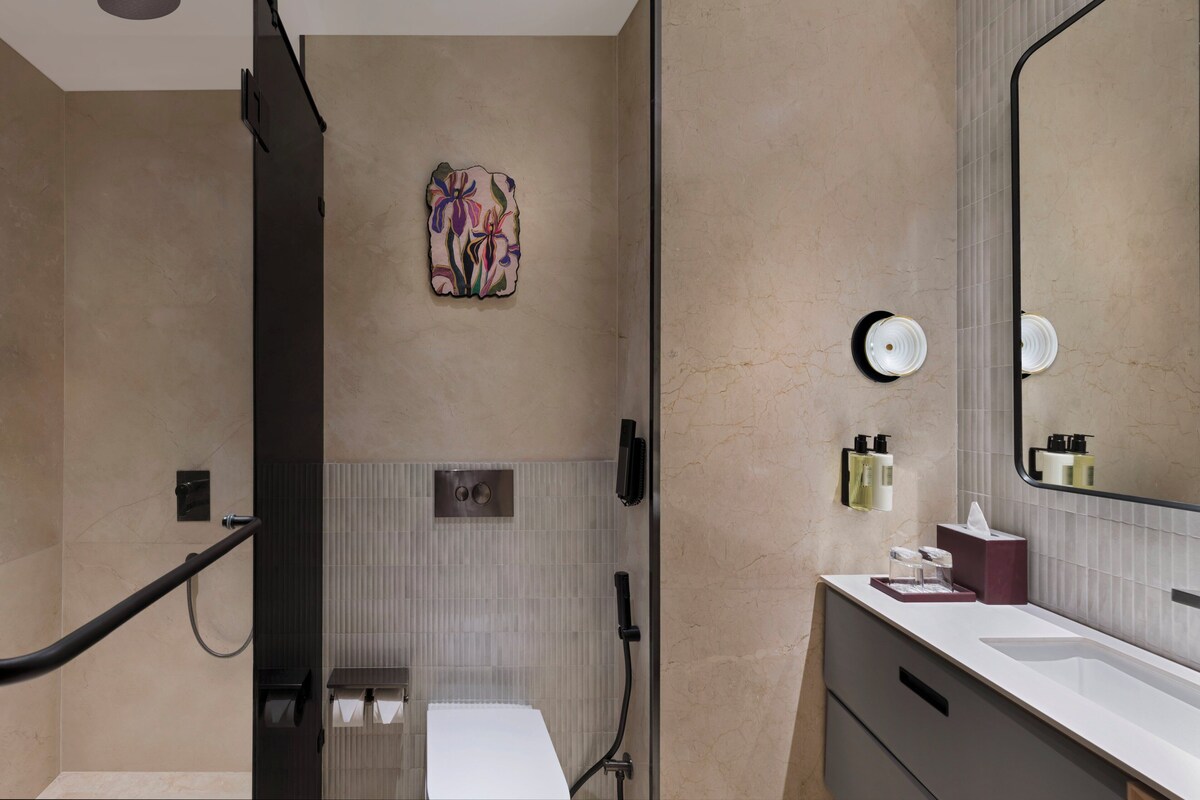 A modern bathroom with a shower, toilet, and sink.