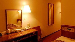 A hotel room with a bed, a desk with a telephone, a mirror, and a wall clock. - Kuretake Inn Iwata (Iwata)