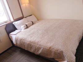 Una cama bien hecha con un edredón estampado, una almohada y un cabecero.