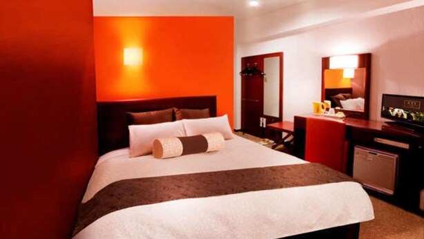 A hotel room with a large bed, a desk with a chair, a mirror, and a television. - Kuretake Inn Yaizu-ekimae (Yaizu)