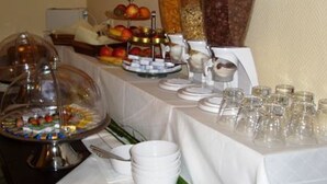 Una barra de buffet con diversos alimentos y utensilios.