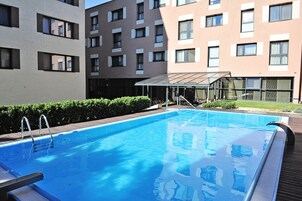 Una piscina al aire libre de temporada, sillones reclinables de piscina
