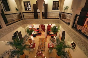 A spacious courtyard with a central seating area, surrounded by balconies with patterned railings. - Riad Shaloma (Marrakech)