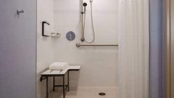 A modern bathroom with a shower, a toilet, and a sink.