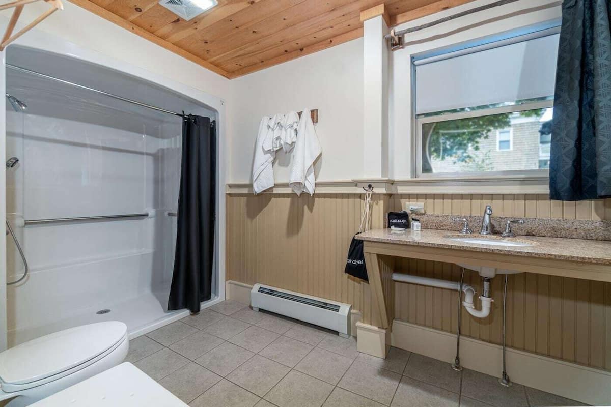 A bathroom with a shower, toilet, and sink.