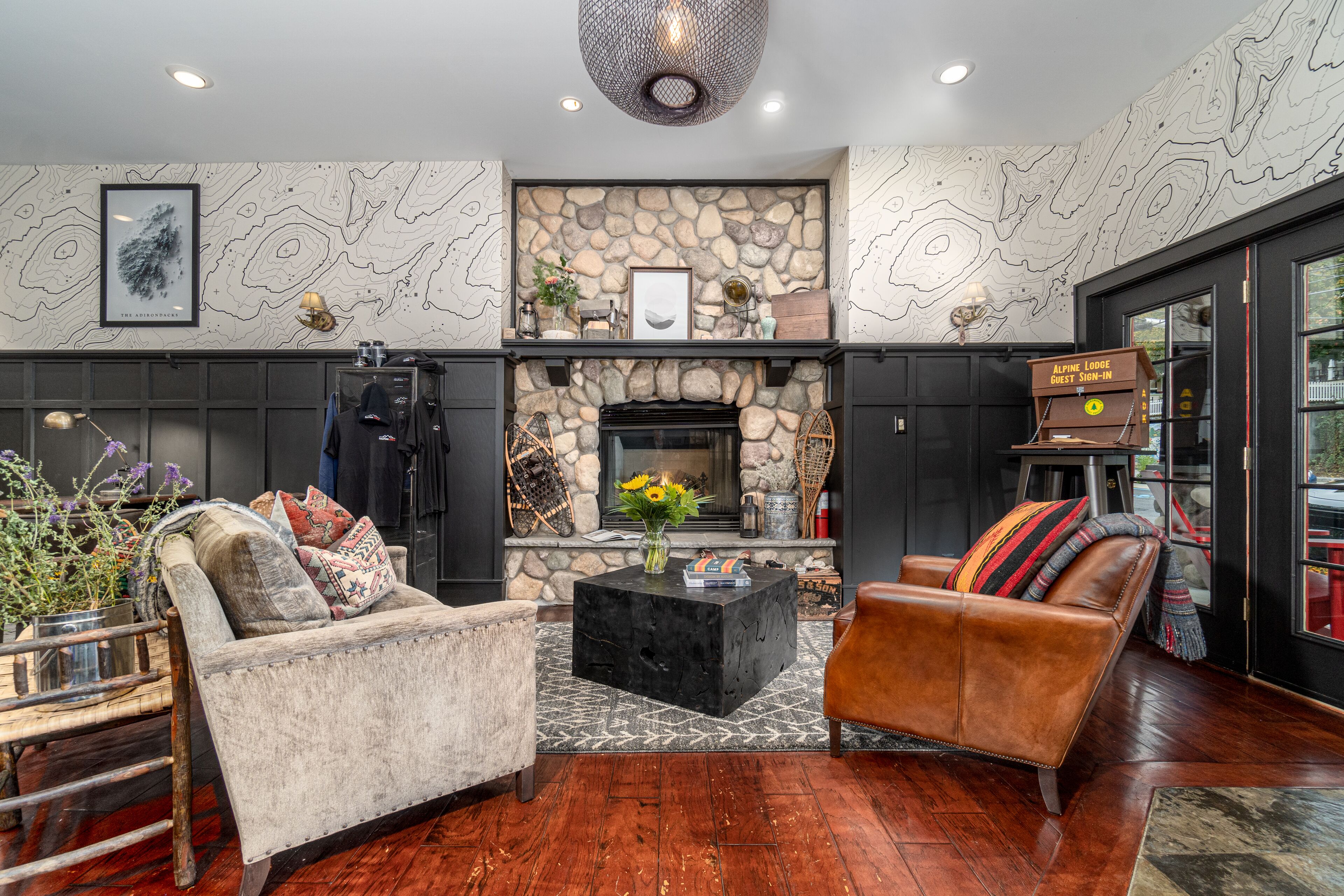 A modern living room with a stone fireplace, leather sofas, and a coffee table.