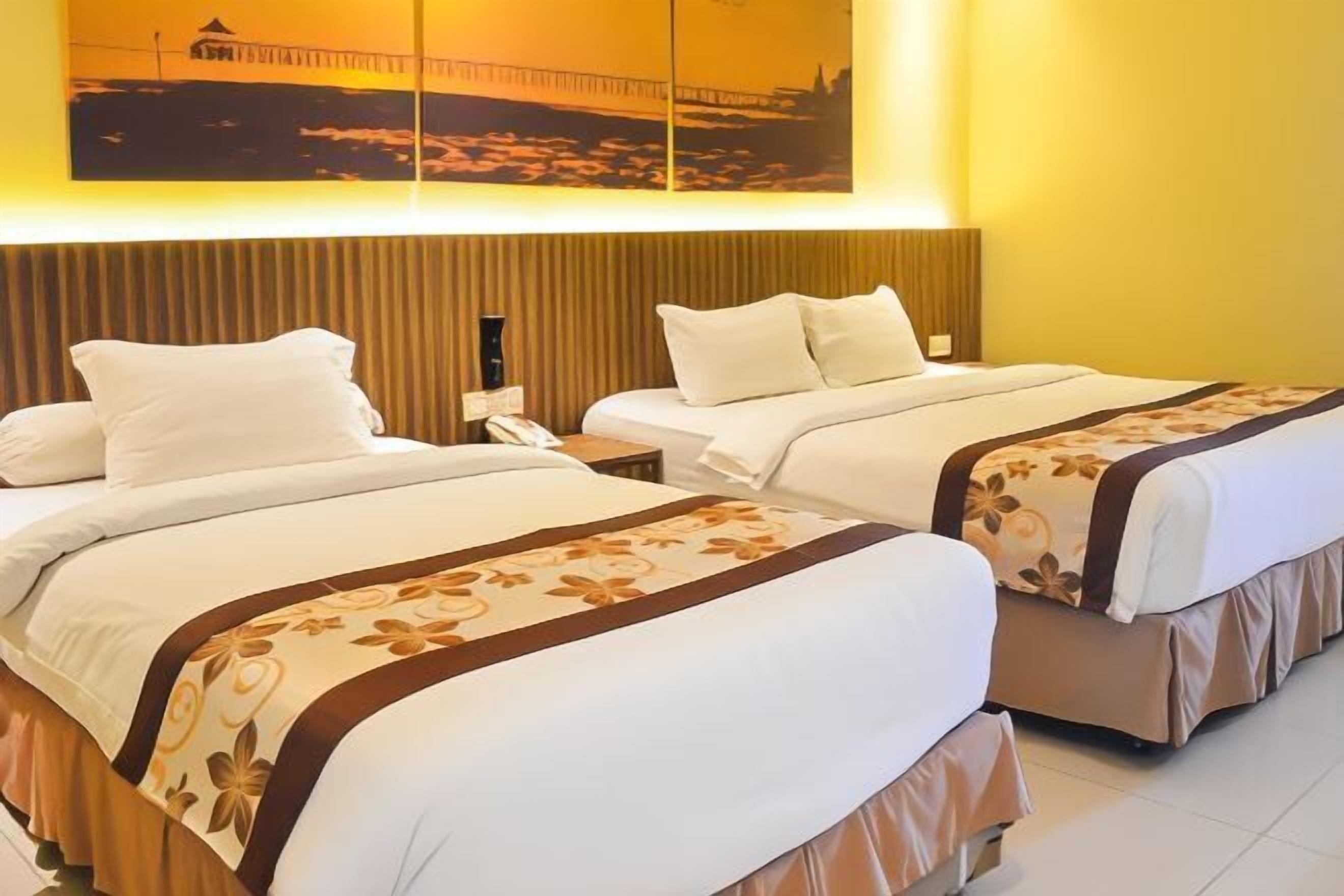 A hotel room with two beds, a wooden headboard, and a wall-mounted artwork.