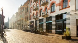 A cobblestone street lined with historic buildings featuring balconies and storefronts. - Antique Apartments Old Town (Kraków)