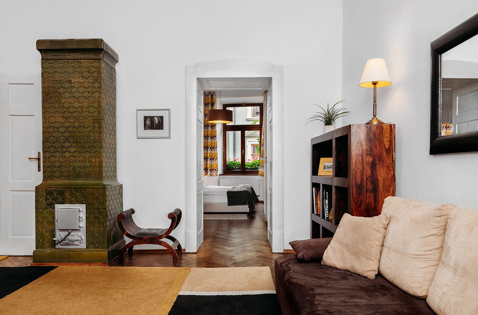 Un salon avec une cheminée, un canapé, une bibliothèque et une lampe.