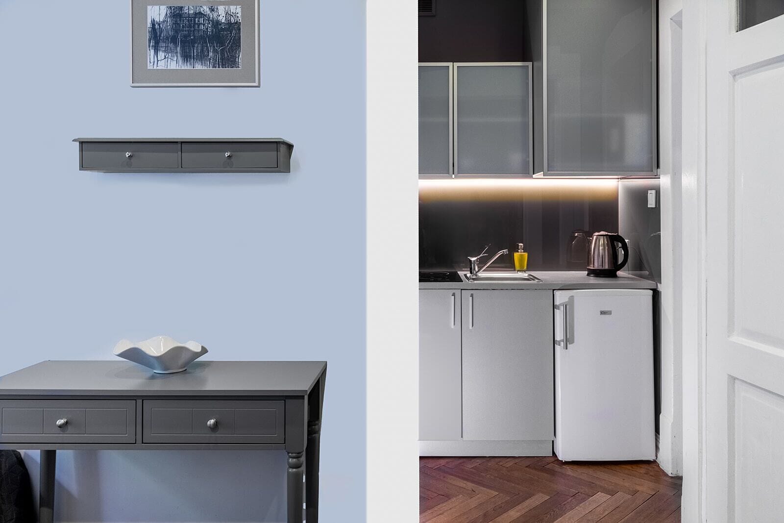 A modern kitchen with a built-in oven, a sink, and a coffee maker.