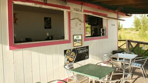 A patio area with outdoor seating, a sign advertising Guinness beer, and a view of the surrounding landscape.