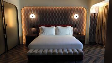 Quarto de hotel moderno com uma cama grande, duas mesas de cabeceira e cabeceira estampada.