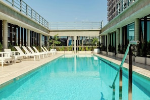 A swimming pool with lounge chairs and a view of a cityscape. - Recoleta Grand, a Tribute Portfolio Hotel (Buenos Aires)