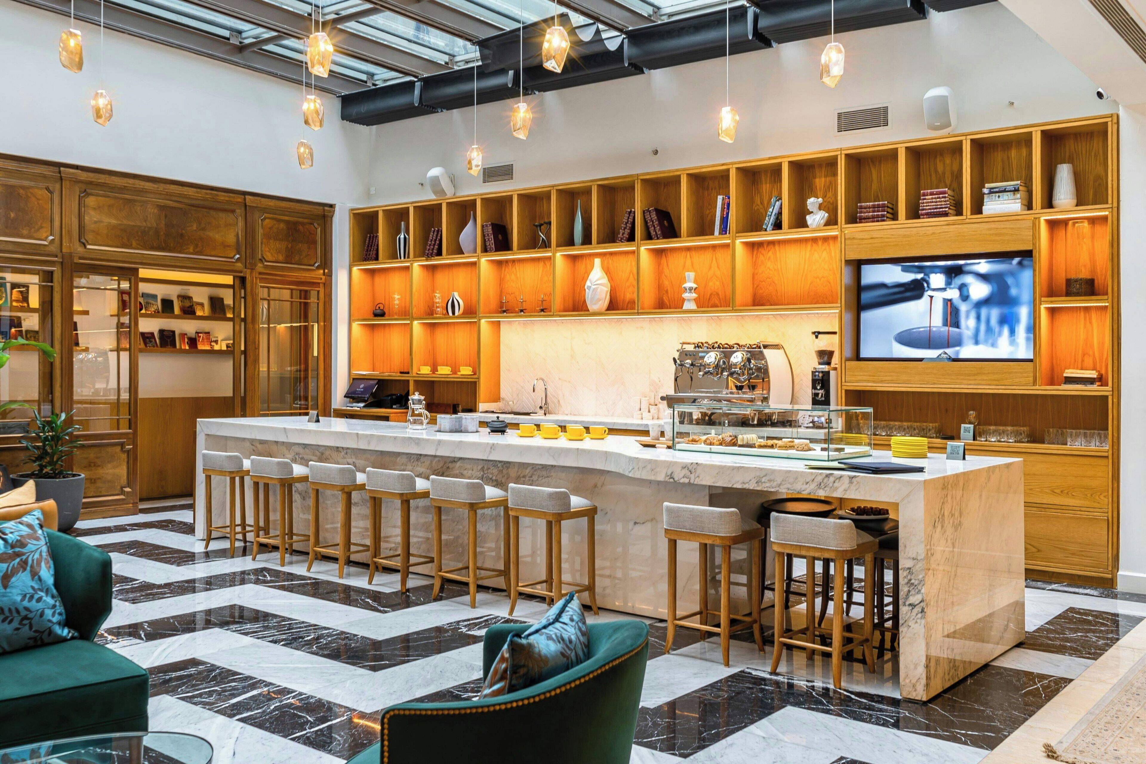Une cuisine moderne dotée d’un îlot central, de tabourets de bar et d’un téléviseur.