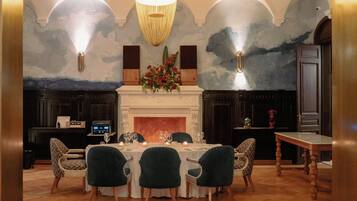 Un comedor con una mesa redonda, sillas, una chimenea y un techo decorativo.