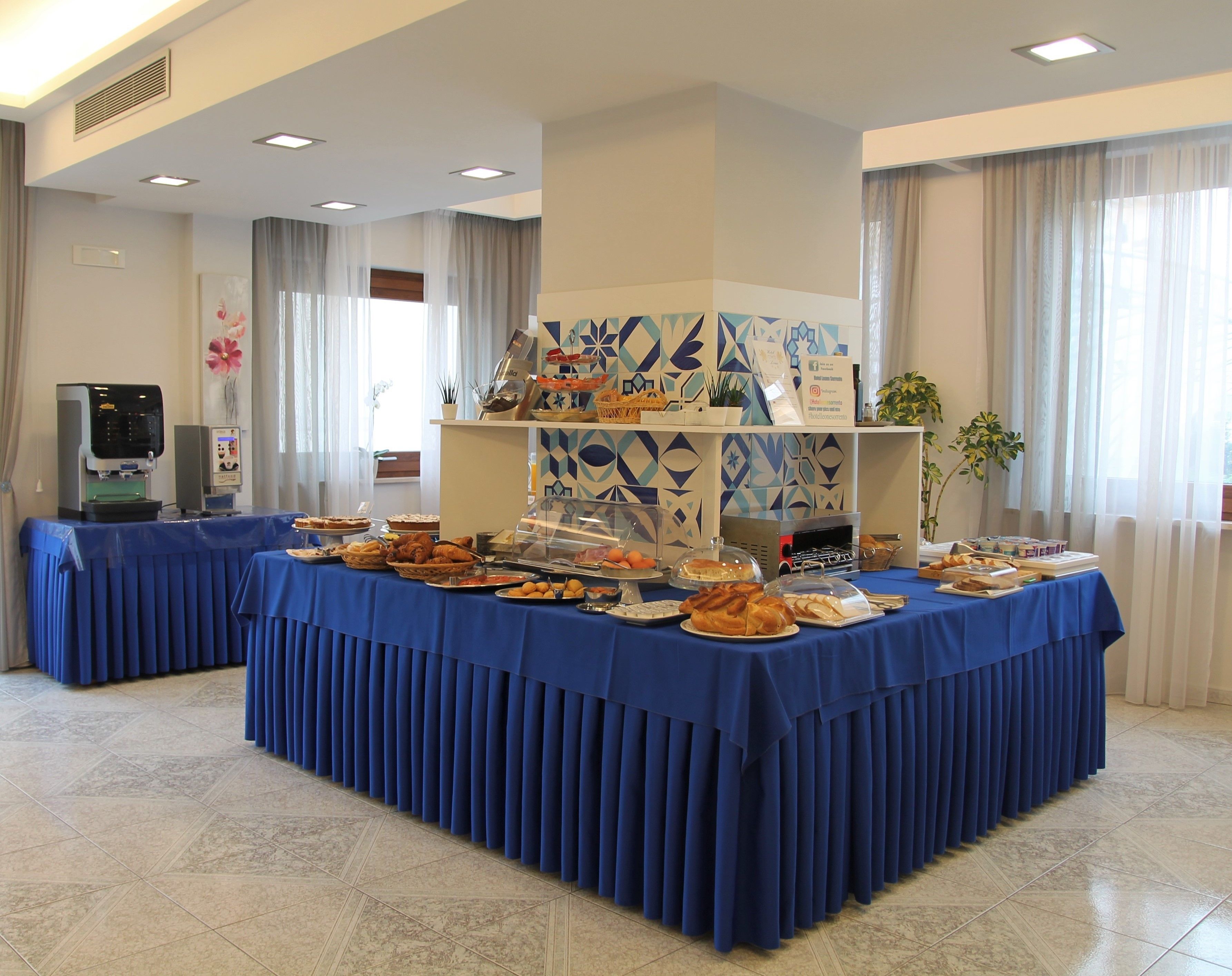 A buffet setup with a variety of food items and a coffee machine.