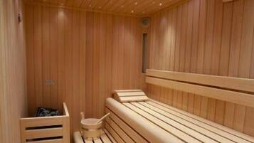 Eine Holzsauna mit Bänken und einer Sitzbank, Holzwänden und Deckenleuchten.
