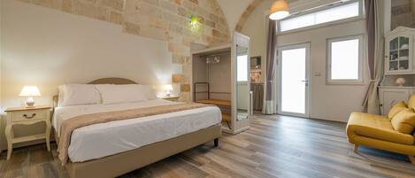 Une chambre à coucher comprenant un lit, des tables de chevet, une armoire et un canapé.