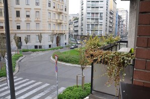 A street view with a pedestrian crossing, a traffic sign, and buildings in the background.