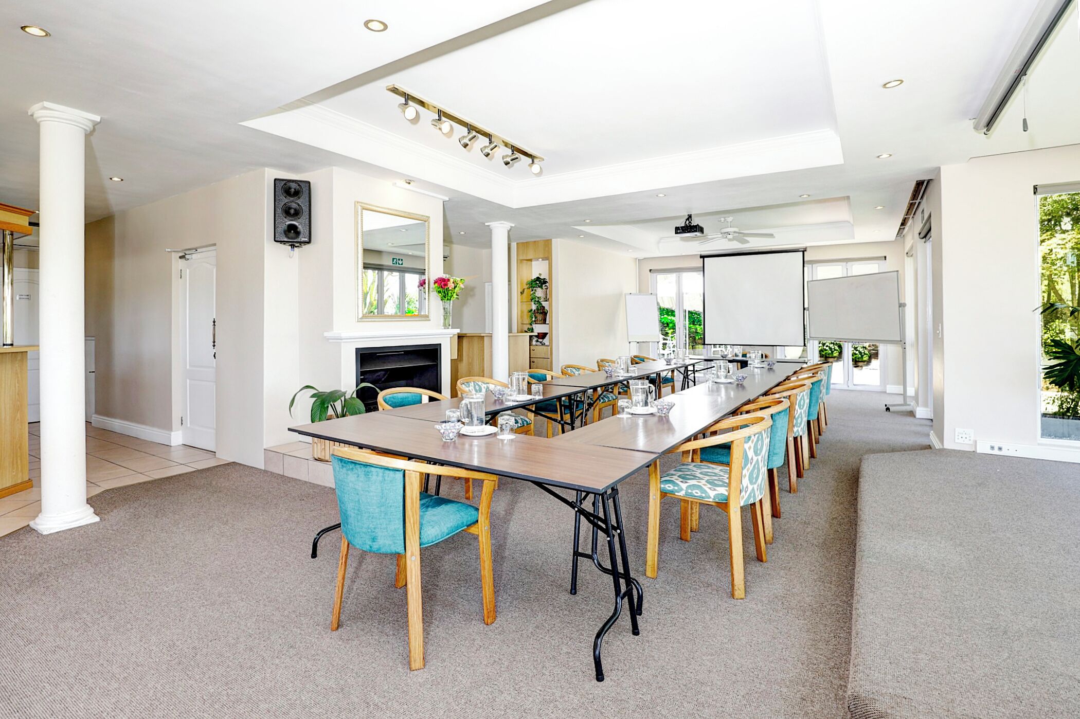 A conference room with a long table, chairs, a fireplace, and a whiteboard.